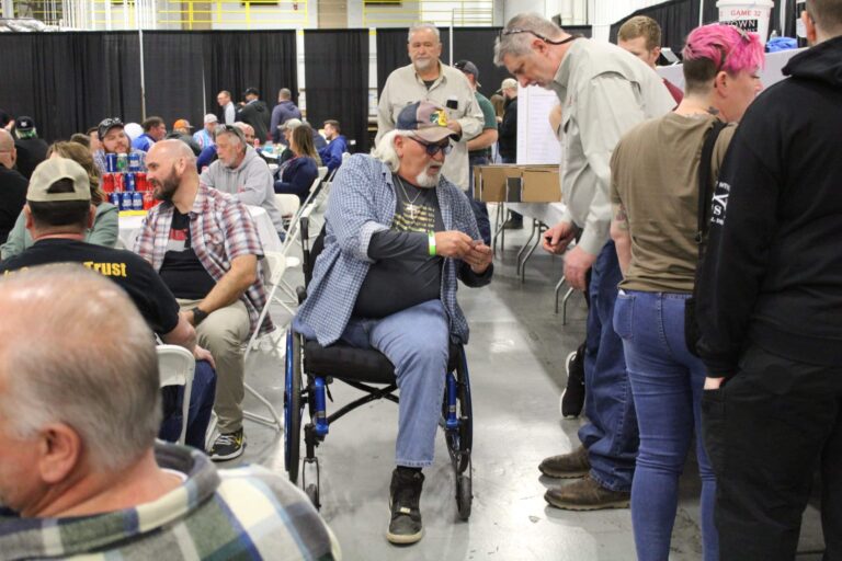 group of men looking at raffle tickets